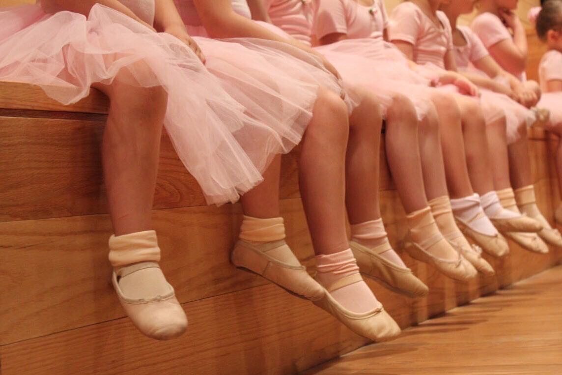 Young dancers sitting on a bench.